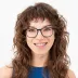 Porträt von Bianca Schedlberger mit lockigem Haar, Brille und blauem Oberteil.